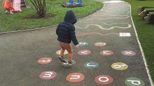 A child jumps around on a playground in Centre 56's sensory garden
